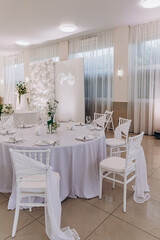 Elegant dining setup for a family celebration with white decor and floral arrangements.