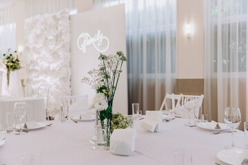Elegant wedding table decor with floral centerpiece and pristine white settings.