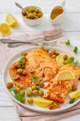 roasted salmon fillet on plate with green olives