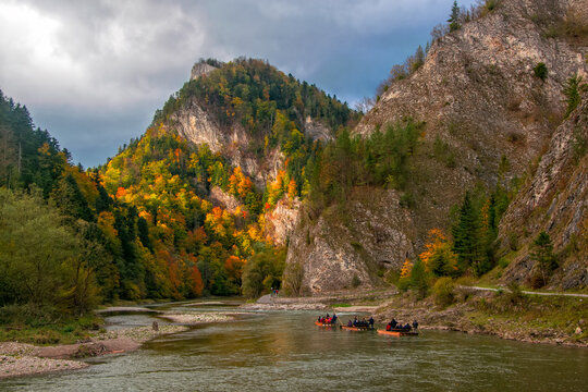 Raft with tourists floating along Dunajec gorge in Pieniny National Park., Poland at sunny autumn day. Dunajec river - popular tourist spot for boat rafting in Poland