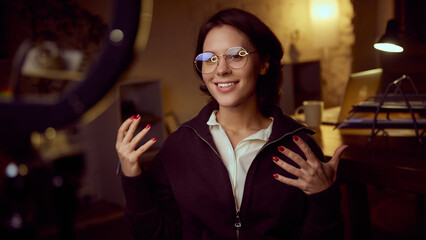 Woman speaking to camera with expressive gestures. Concept of coaching, online media talks, personal brand communication, psychology insights, education content creation, confident emotional delivery.