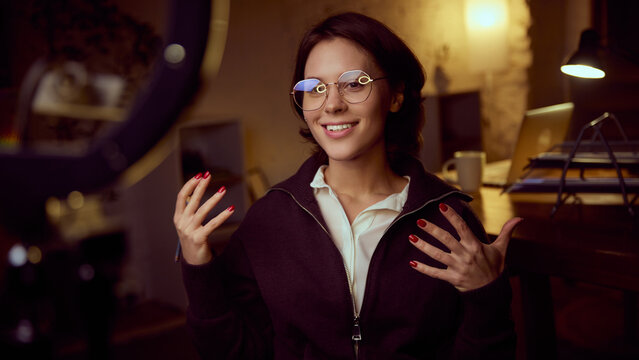 Woman speaking to camera with expressive gestures. Concept of coaching, online media talks, personal brand communication, psychology insights, education content creation, confident emotional delivery.