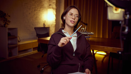 Woman explaining idea with pencil during online session. Concept of online education, coaching formats, structured thinking, digital learning and professional self-development communication.