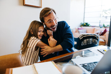 Joyful father and daughter hug at home