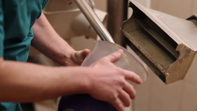 technician hands, prosthetic fabrication, smooth finish. Detailed view of technician's hands shaping transparent prosthetic socket on industrial grinder during custom limb preparation