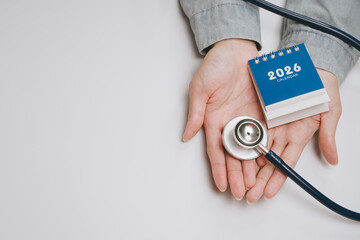 Naklejka na ściany i meble 2026 calendar with stethoscope in hand symbolizing health checkup and medical appointment planning for future