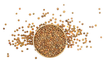 Brown uncooked lentils pile in wooden cup isolated on white background, top view