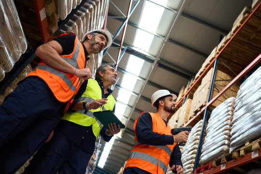 Warehouse workers checking inventory with scanner and clipboard