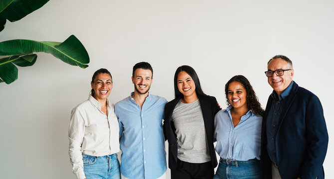 Multi generational workers smiling in front of camera inside business office - Multiracial entrepreneur and teamwork concept - Main focus on asian girl face