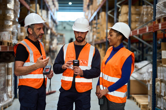 Warehouse workers discussing logistics and inventory management