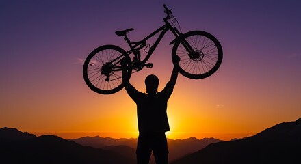 Silhouette of a triumphant mountain biker holding his bike overhead against a vibrant sunset sky, celebrating achievement on a mountain peak.