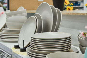 Stacks of white plates on a shelf in a store for sale
