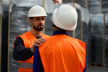 Construction workers discussing project in warehouse