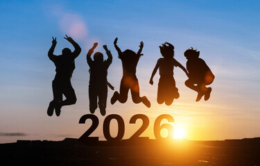 Happy group of people celebrate jump for new year 2026. concept for win victory. silhouette of friends jumps at sunset time on mountains.