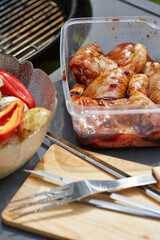 Marinating chicken drumsticks and vegetables for outdoor grilling