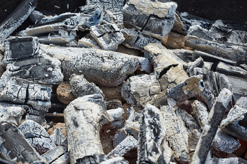 Glowing embers and burnt wood after barbecue fire