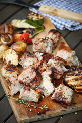 Grilled pork shashlik with vegetables on cutting board