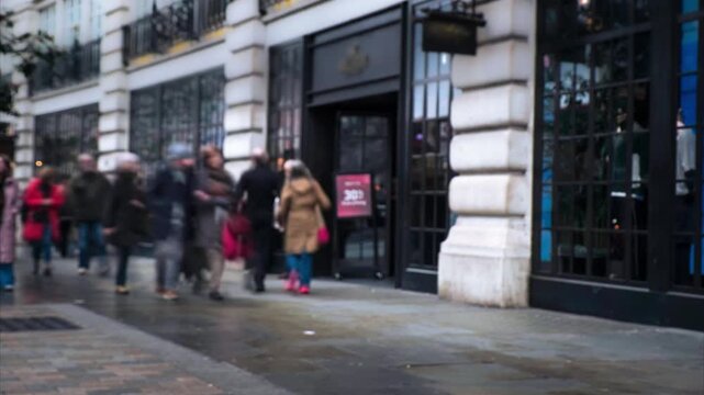 Timelapse of busy street of people in retail shop high street setting - London