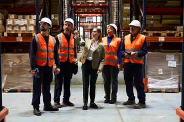 Warehouse manager and workers discussing a logistics inspection