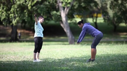 Two women synchronized stretching during outdoor park workout - Powered by Adobe