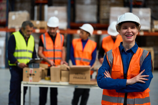 Happy warehouse worker smiling with diverse team