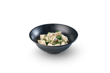 Pelmeni dumplings with dill in black bowl