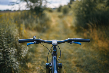 Mountain bike handlebar featuring a gps computer, navigating a winding forest trail and providing an exhilarating cycling experience