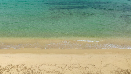 Aerial view of a sandy beach and a dreamlike sea. There's no one on the sand on this beautiful, sunny summer day. Holiday concept.