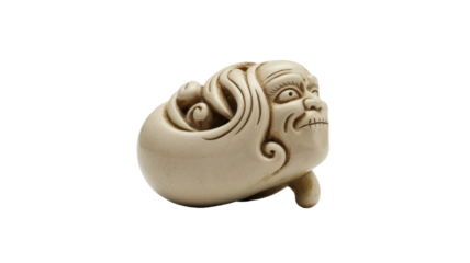 An intricately carved antique Japanese Netsuke, depicting a grotesque mythical creature or demon head with an expressive, fierce face. Beige material. background removed