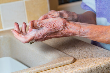 Older person with arthritis washing hands, aged person personal hygiene concept