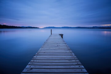 Twilight pier moment caught as fading pastel light drifts softly across still reflections