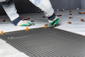 Fototapeta premium Installing the tiling system (clips) before laying tiles.