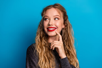 Bright smiling woman with braces wearing glittery dress poses against blue background for beauty...