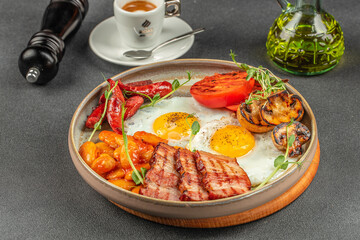 Hearty full breakfast plate with fried eggs, grilled bacon, sausages, beans, mushrooms and tomato served in a cozy cafe setting with espresso for food advertising and menu design