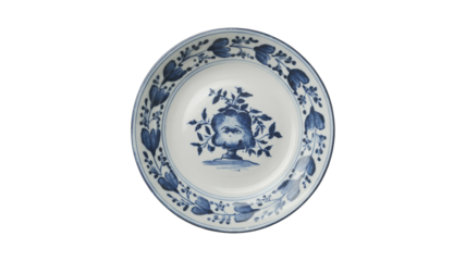 A classic white ceramic plate featuring intricate blue floral and botanical patterns. A central vase motif is surrounded by a delicate border. background removed
