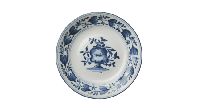 A classic white ceramic plate featuring intricate blue floral and botanical patterns. A central vase motif is surrounded by a delicate border. background removed - Powered by Adobe