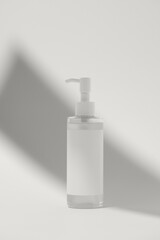Blank label on product bottle in shadow on background. Modern cosmetic presentation color of 2026 year cloud white