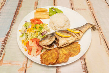 Whole fried fish, Venezuelan beach style, with tostones, avocado salad, and charcoal-grilled arepas