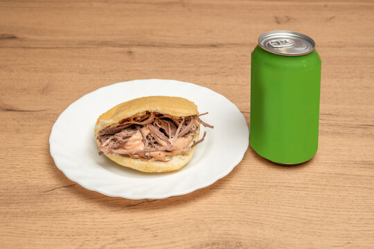 Venezuelan arepa filled with shredded beef, hard white cheese, and avocado, perfectly browned on a griddle with its characteristic golden color