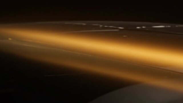 Elegant golden cinematic light sweep transitioning smoothly across a dark polished surface creating a stylish atmosphere premium, subtle, design