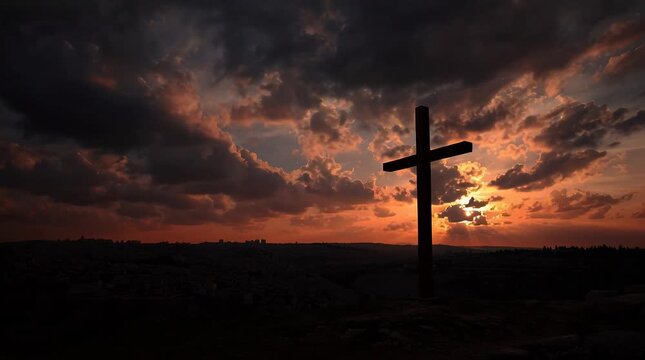 Silhouette of Christian Cross on Hill against Dramatic Sunset Sky for Easter and Good Friday Concept