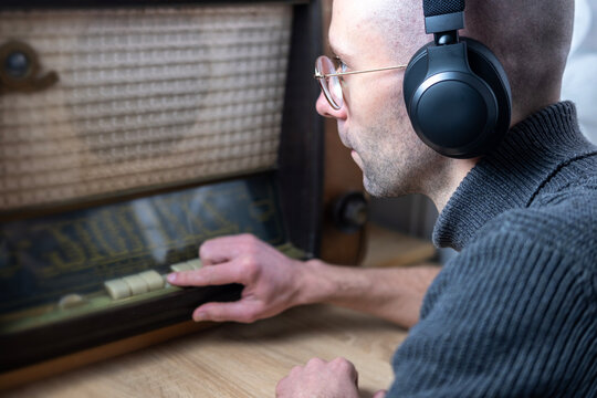Positive Young man in wireless headphones, listen to old Vintage 60s radio, happily while listening to music, podcast, Retro aesthetic