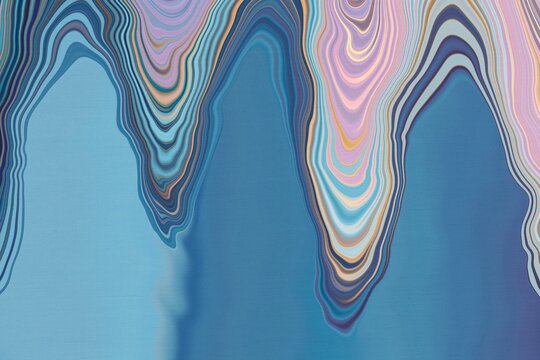 Colorful waves of blue and pink patterns create a unique abstract design on the canvas surface in a bright space