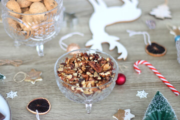 Various Christmas decorations, cookies, chocolate and nuts on wooden background. Selective focus.