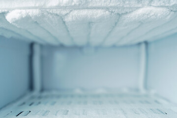 Empty frosty freezer interior with ice buildup and copy space, background for freezing services,...