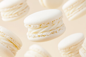 2026 color trend. Off-white macarons floating in a whimsical pattern against a soft background, showcasing their delicate texture and sweet filling, perfect for dessert lovers and culinary enthusiasts