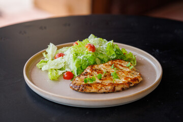 Grilled Chicken Breast With Fresh Green Salad On Plate Outdoors