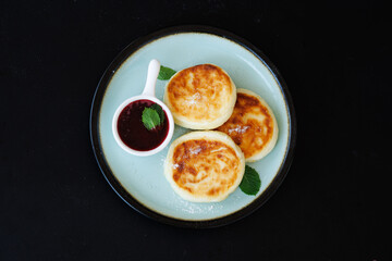 Golden-Brown Cottage Cheese Pancakes With Berry Sauce And Fresh Mint On A Plate For Breakfast Or Dessert