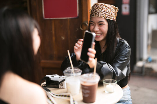 Two young asian woman gen z using smartphone share lifestyle happiness travel moment on social media in Bangkok