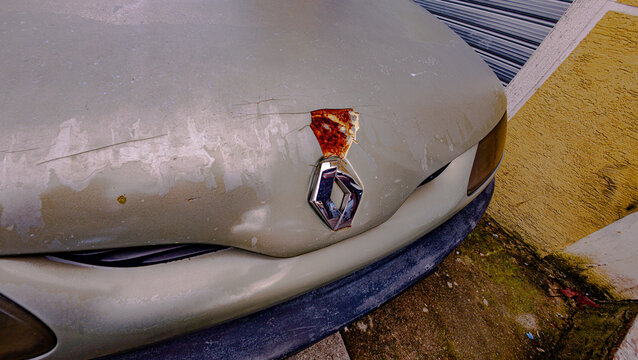 Close-up of the Renault car emblem on a rusty hood. Detailed automotive photography highlighting corrosion, texture, and the metallic logo in Durres, Albania 11.11.2025